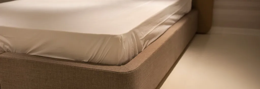 Wit hoeslaken strak om de hoek van een matras